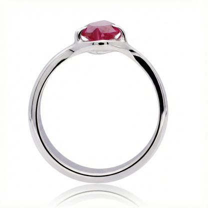 Anillo de plata 925 con una piedra color rojo tinto en forma de corazon, el anillo esta parado